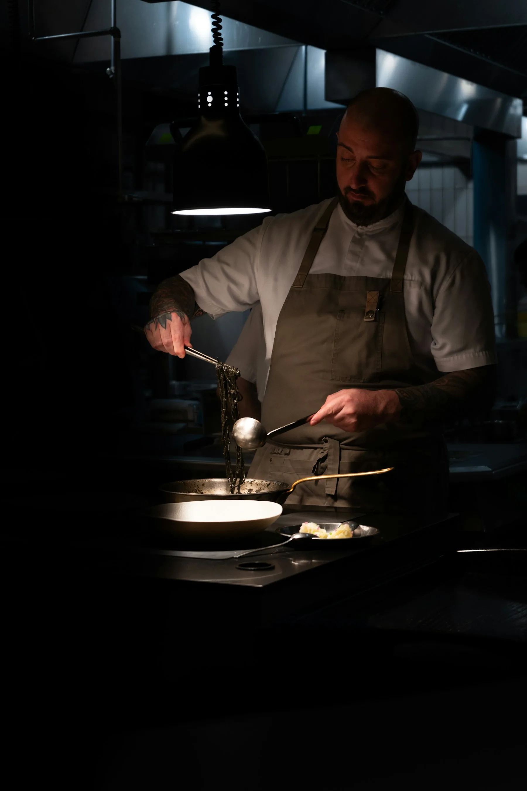 Le chef Élias Morel dressant une assiette en cuisine